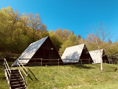 Zeltplatz-Hütten im Ferienzentrum Albert Schweitzer Mehrere A-förmige Zeltplatz-Hütten aus Holz auf einer grünen Wiese im Ferienzentrum Albert Schweitzer in Vöhl.