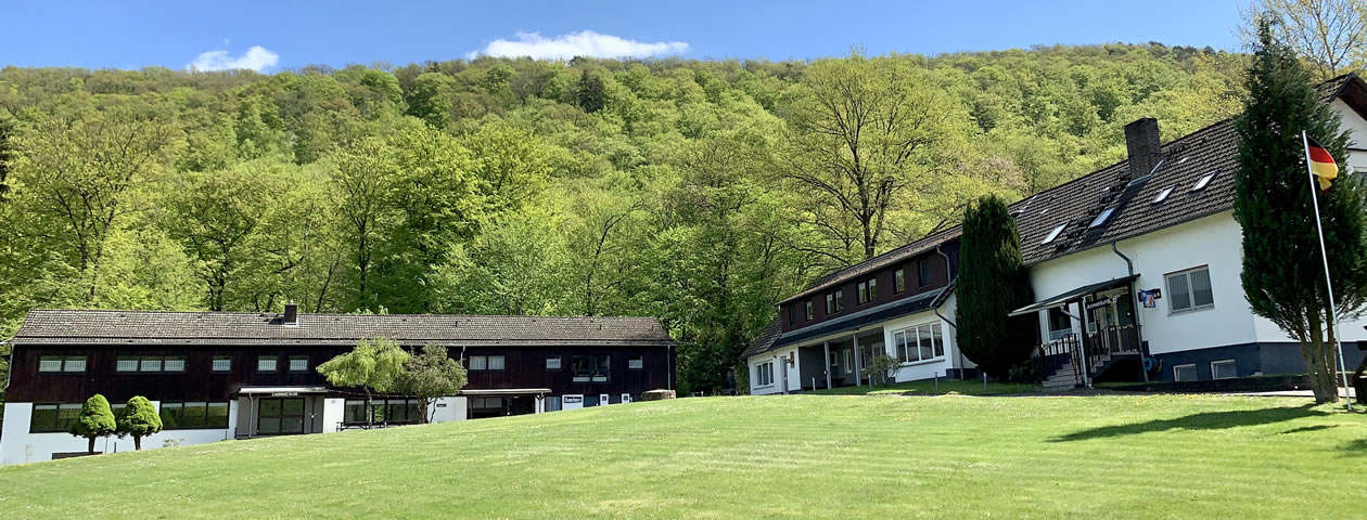 Aussenbereich Ferienzentrum Albert Schweitzer Vöhl Der Außenbereich des Ferienzentrums Albert Schweitzer in Vöhl mit Gebäuden, Tischen und einem Wald im Hintergrund