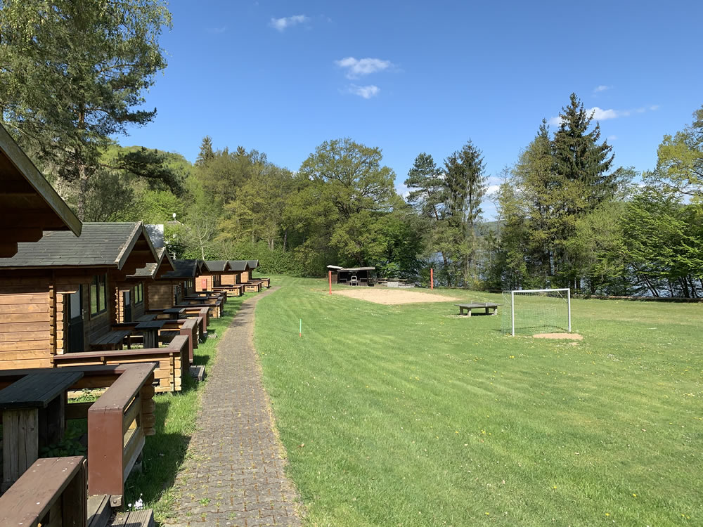 Ferienhäuser und Sportplatz am Edersee Holzhäuser am Edersee im Ferienzentrum Albert Schweitzer in Vöhl neben einem Sportplatz.
